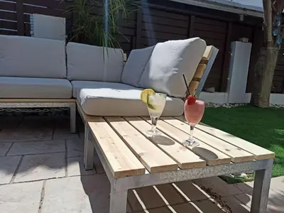 a wooden coffee table with two drinks on it at Casa Palmera in Paralimni