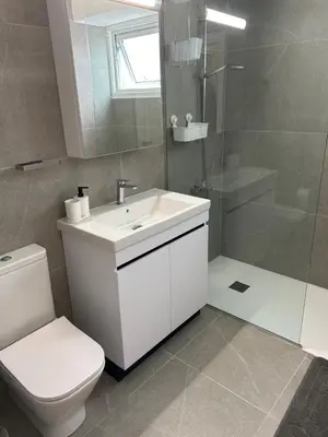 a bathroom with a toilet and a sink and a shower at Haris' Apartment Larnaca in Larnaka