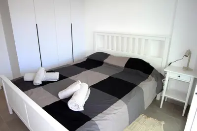 a bedroom with a black and white bed with towels on it at Haris' Apartment Larnaca in Larnaka