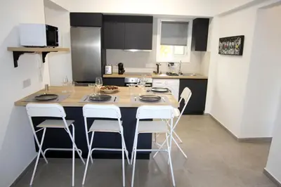 a kitchen with a table and chairs in a kitchen at Haris' Apartment Larnaca in Larnaka