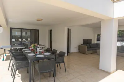 a dining room and living room with a table and chairs at Mylos Villas in Protaras