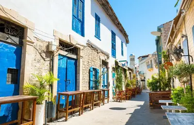 a street with tables and chairs in an alley at Diana Apartment in Limassol