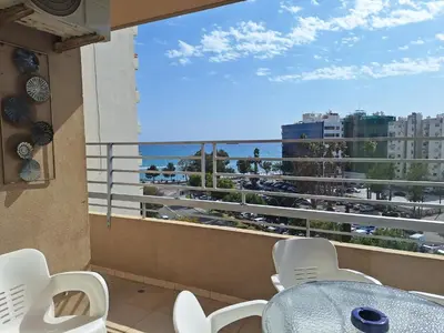 a balcony with a table and chairs and a view of the ocean at Diana Apartment in Limassol