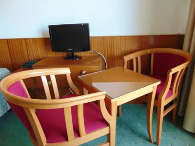 a room with a desk and two chairs and a tv at Hellas Hotel in Kakopetria