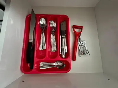 a red tray with silver utensils on a counter at Your place for relax in Larnaka