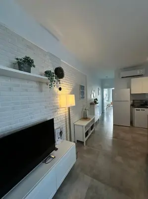 a living room with a flat screen tv on a brick wall at Your place for relax in Larnaka