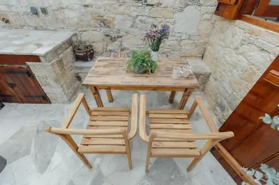 a wooden table and four chairs on a patio at The Yard Traditional Residence in Vasa Kilaniou