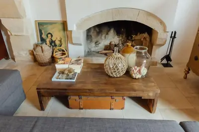 a living room with a coffee table with a fireplace at The Yard Traditional Residence in Vasa Kilaniou