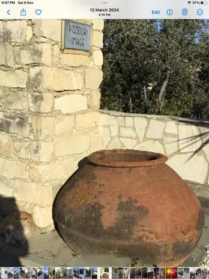 a large clay vase sitting next to a stone wall at Pissouri Beach House - Image in Pissouri