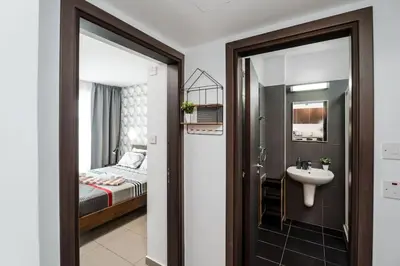 a bathroom with a sink and a bedroom with a bed at SunnyVillas 1 Bedroom Swimming Pool COR in Protaras