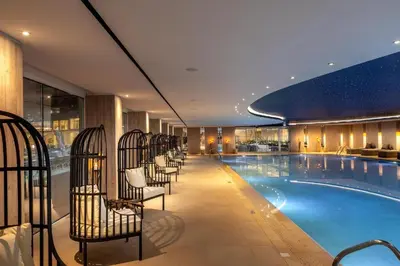 a pool in a hotel with chairs next to it at The HEALTHY Stay-Padel, Pool&Fitness in Ayia Napa