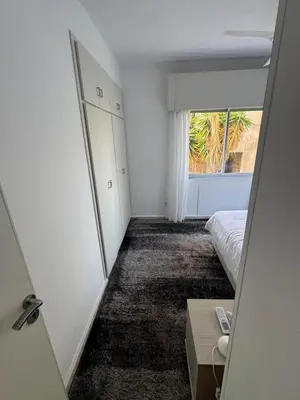 an empty room with a bed and a window at Georges 2 Bedroom Apartment in Limassol