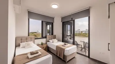 a bedroom with two beds and a balcony at Villa Iva by the Sea in Paralimni