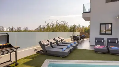 a patio with chairs and a pool on a building at Villa Iva by the Sea in Paralimni