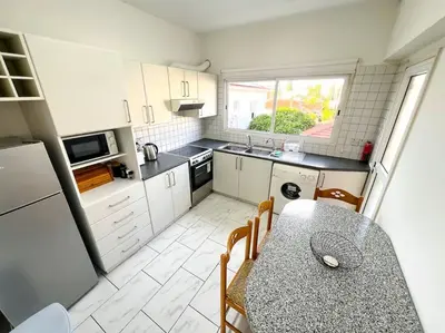 a kitchen with a table with chairs and a counter top at Samos City Center, 2BR Sleeps 4 in Limassol