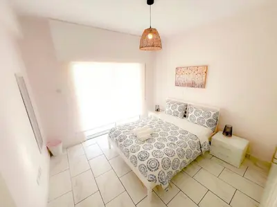 a bedroom with a bed and a large window at Samos City Center, 2BR Sleeps 4 in Limassol
