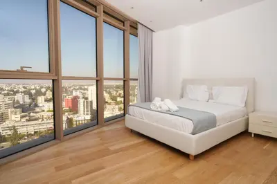a bedroom with a white bed and large windows at WealthyStays 360 Luxury Residence in Nicosia