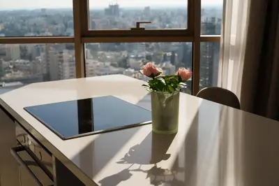 a vase with flowers sitting on a table in front of a window at WealthyStays 360 Luxury Residence in Nicosia