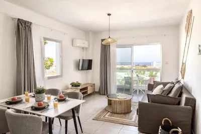 a living room with a couch and a table and chairs at Somantonia apartments in Protaras