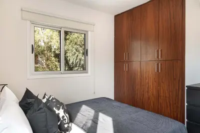 a bedroom with a bed and a wooden cabinet at Phaedrus Living Evergreen Nicosia City Residence in Nicosia