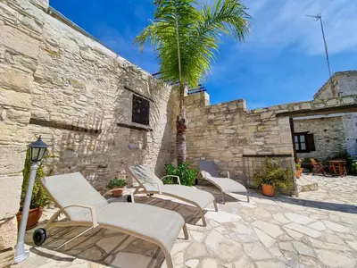 a group of chairs and a palm tree on a patio at Skarinou Panorama Room in Skarinou