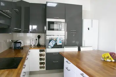 a kitchen with black cabinets and a wooden counter top at Freshness Modern 2 Bedroom Apartment with Balcony & Stunning Sea View in Central Limassol in Limassol