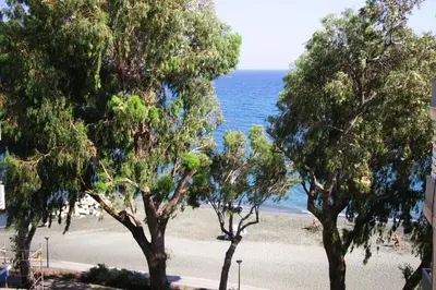a beach with trees and the ocean in the background at Freshness Modern 2 Bedroom Apartment with Balcony & Stunning Sea View in Central Limassol in Limassol