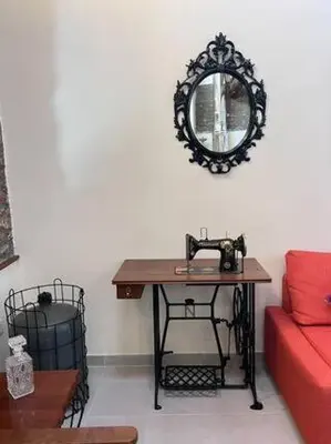 a room with a table with a mirror and a red couch at Finikous Cottage House-Agros in Agros