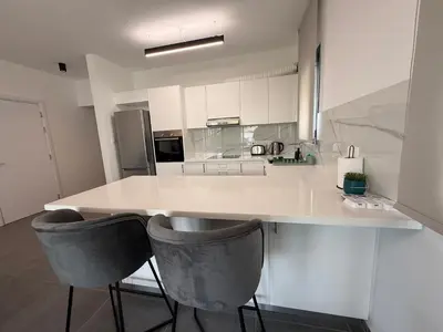 a kitchen with a white counter and two bar stools at Glabur Stays - Nicosia Elite 2BDR in Nicosia