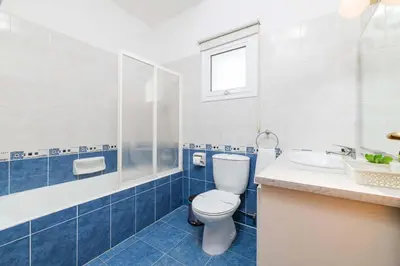 a blue and white bathroom with a toilet and a sink at Villa Kos #7 in Paralimni
