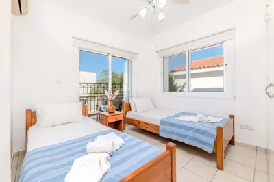 a bedroom with two beds and a window at Villa Kos #7 in Paralimni