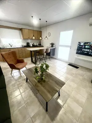 a living room with a table and a kitchen at Cosy Refurbished Apt City Centre in Limassol