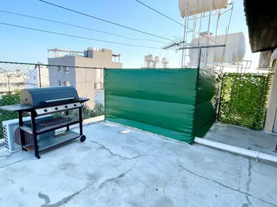 a grill sitting on top of a patio at Cosy Refurbished Apt City Centre in Limassol