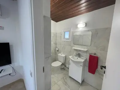 a white bathroom with a toilet and a sink at Cosy Refurbished Apt City Centre in Limassol