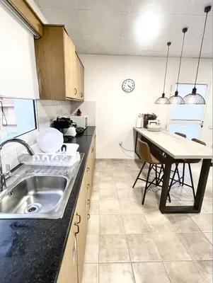 a kitchen with a sink and a table at Cosy Refurbished Apt City Centre in Limassol