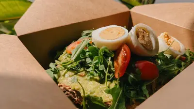 a box filled with a salad with a hard boiled egg at Alinea Lano Old Town Center in Limassol