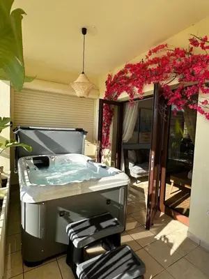 a jacuzzi tub on a patio with flowers at Bohemian Oasis in Episkopi Lemesou