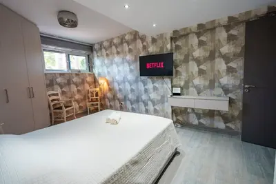 a bedroom with a bed and a tv on the wall at Royal Nissi Mansion 3 bed lower part of villa in Ayia Napa