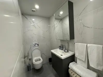 a white bathroom with a toilet and a sink at Courtyard Holiday Resort Studio in Iskele