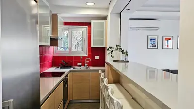 a kitchen with red walls and white counters at Phaedrus Living Limassol Ocean Pearl Residence in Limassol