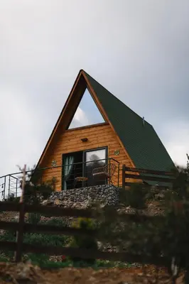 a log cabin with a large window and a fence at Cozy Glamping Cabin for Couples and Families in Arakapas