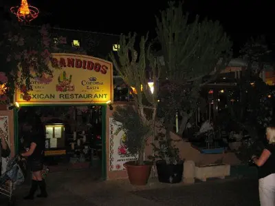 a group of people standing outside of a store at night at Ayia Napa Apartment in Ayia Napa