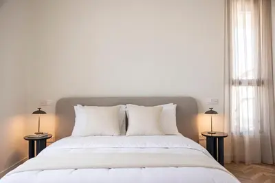 a white bed with white pillows and two lamps at Interlace by Holistays in Engomi