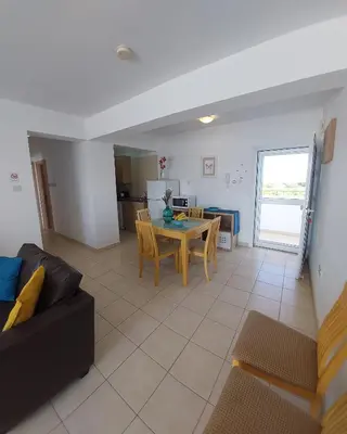a living room with a couch and a table at Tide Terrace 2 bdr apt in Kapparis, Protaras in Paralimni