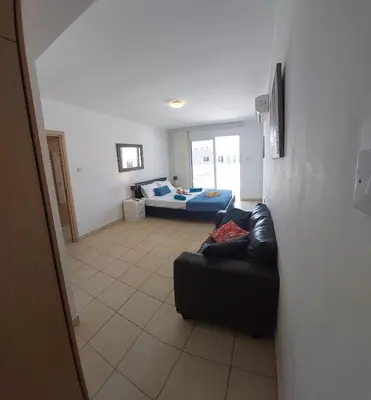 a living room with a couch and a bed at Tide Terrace 2 bdr apt in Kapparis, Protaras in Paralimni