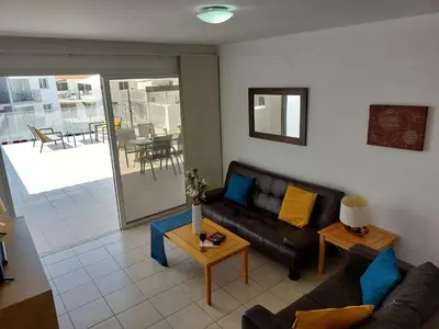 a living room with a couch and a table at Tide Terrace 2 bdr apt in Kapparis, Protaras in Paralimni