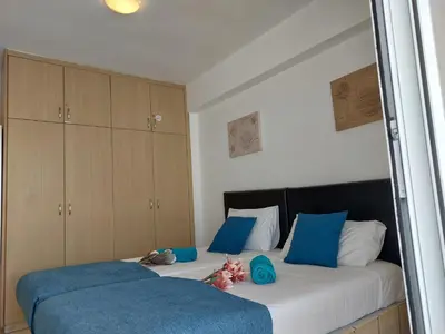a bedroom with two beds with blue pillows at Tide Terrace 2 bdr apt in Kapparis, Protaras in Paralimni
