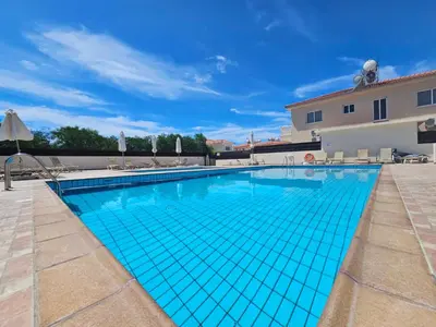 a large swimming pool with blue tiles on it at Nissi Retreat - Walk to Nissi beach! in Ayia Napa