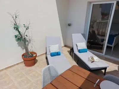 a living room with two chairs and a table at Nissi Retreat - Walk to Nissi beach! in Ayia Napa