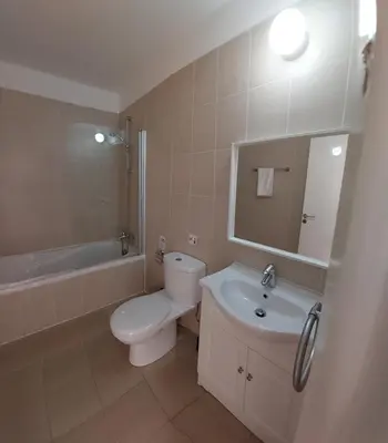 a bathroom with a toilet and a sink and a mirror at Nissi Retreat - Walk to Nissi beach! in Ayia Napa